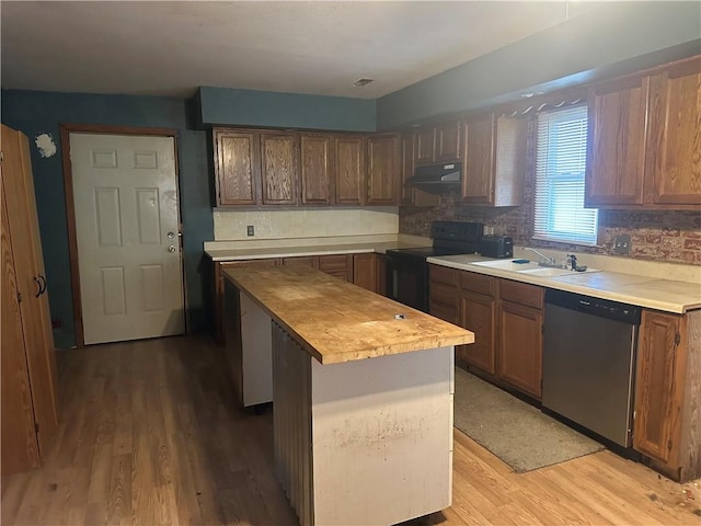 kitchen featuring black range with electric stovetop, dishwasher, light wood-type flooring, and a center island