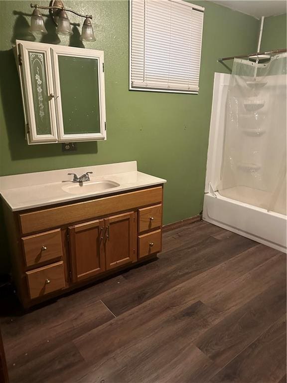 bathroom with walk in shower, vanity, and hardwood / wood-style floors