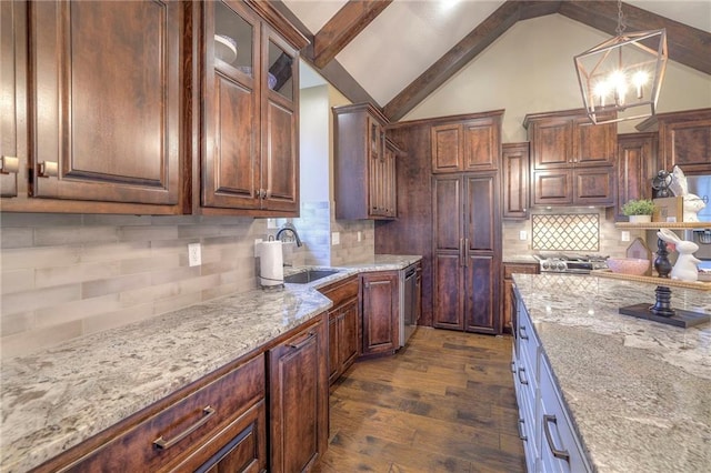 kitchen with dark hardwood / wood-style flooring, sink, pendant lighting, and light stone counters