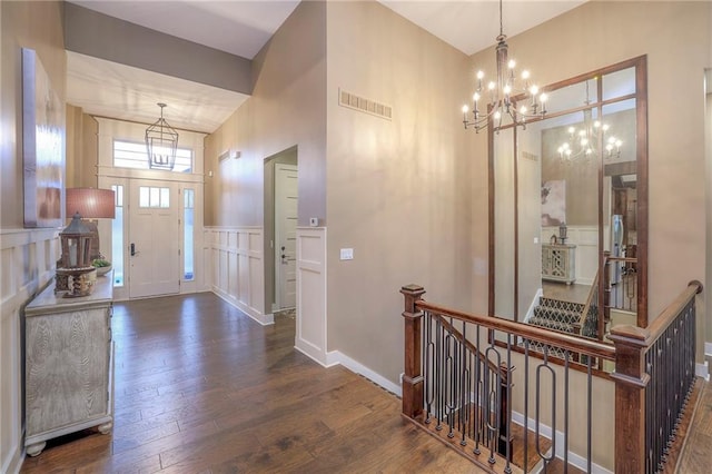 foyer with dark wood-type flooring and a chandelier