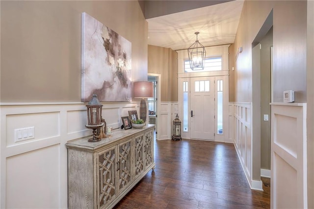 foyer entrance with a notable chandelier and dark hardwood / wood-style floors