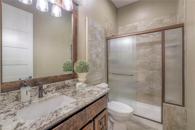 bathroom featuring toilet, vanity, and walk in shower