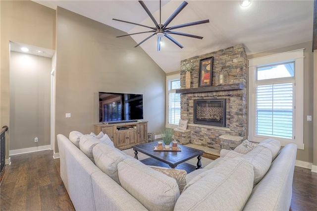 living room featuring dark hardwood / wood-style floors, a stone fireplace, and high vaulted ceiling