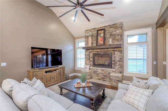 living room with lofted ceiling, plenty of natural light, a fireplace, and light wood-type flooring