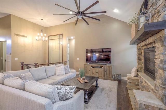 living room featuring hardwood / wood-style flooring, a fireplace, high vaulted ceiling, and a notable chandelier