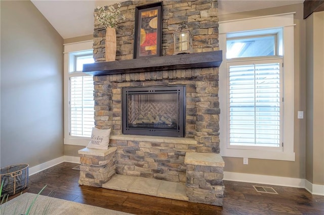 details with hardwood / wood-style flooring and a stone fireplace