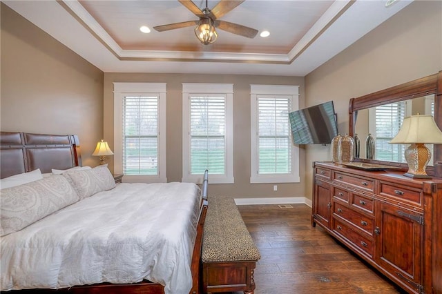 bedroom featuring ceiling fan, dark hardwood / wood-style flooring, and a raised ceiling