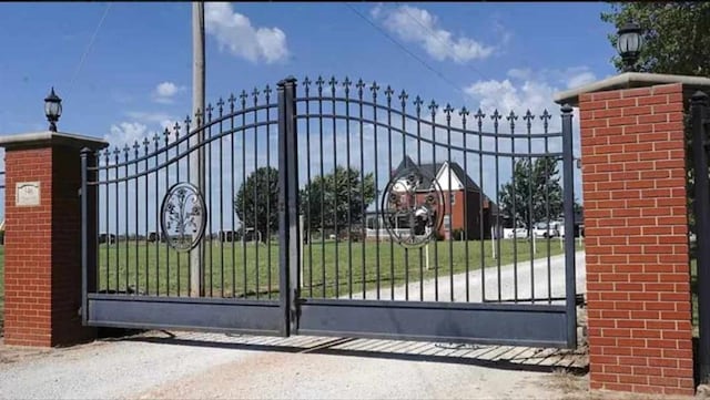 view of gate with a lawn