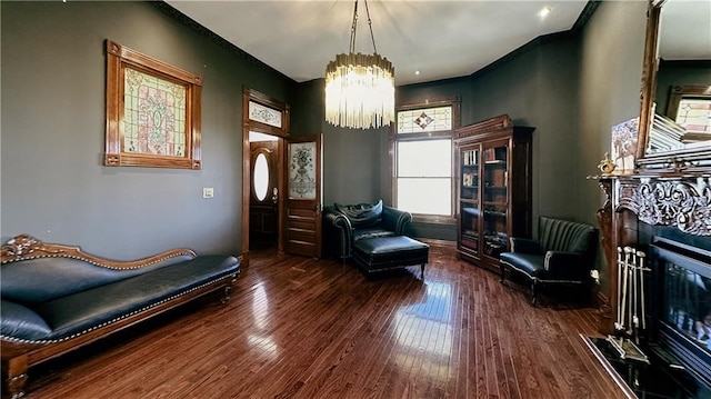 sitting room featuring a notable chandelier, a fireplace, and dark wood-type flooring