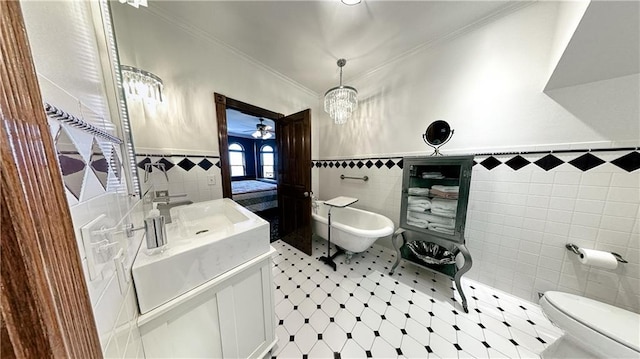 bathroom featuring vanity, tile walls, tile floors, toilet, and a bidet