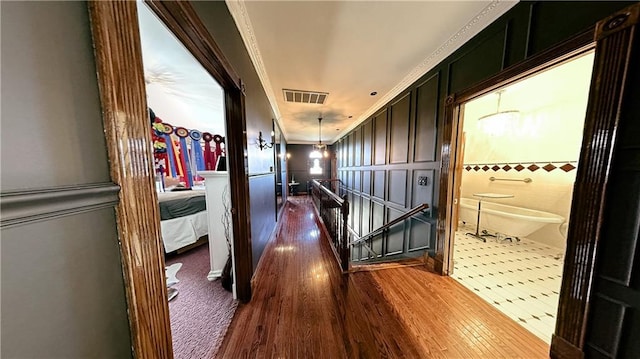 hall with dark tile flooring and ornamental molding