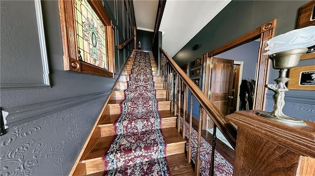 stairs featuring crown molding and dark hardwood / wood-style floors