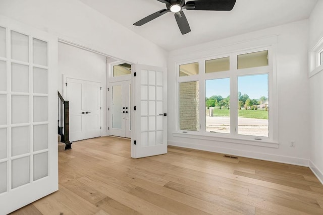 interior space with light wood-type flooring, ceiling fan, and french doors