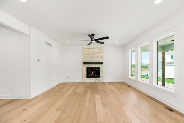 unfurnished living room featuring ceiling fan, light hardwood / wood-style floors, and a fireplace