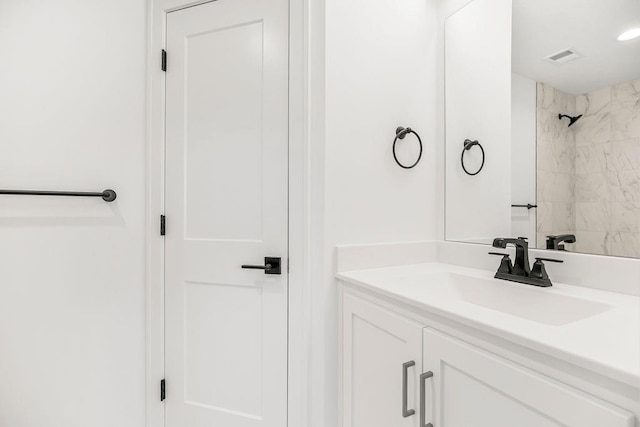 bathroom with vanity and a tile shower