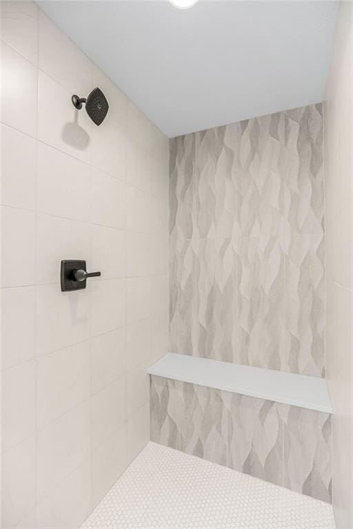 bathroom featuring tile walls and a tile shower