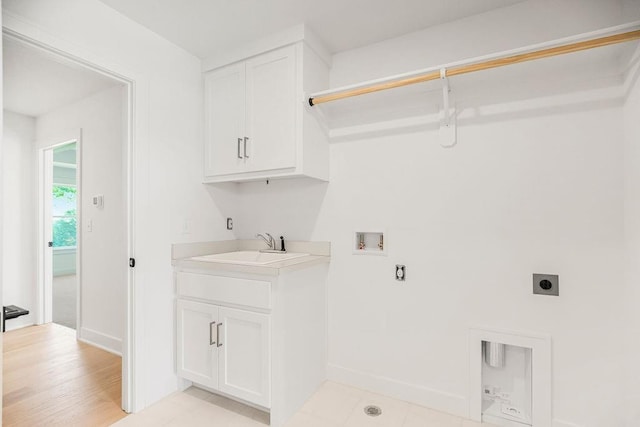 washroom featuring washer hookup, sink, hookup for an electric dryer, cabinets, and light hardwood / wood-style floors