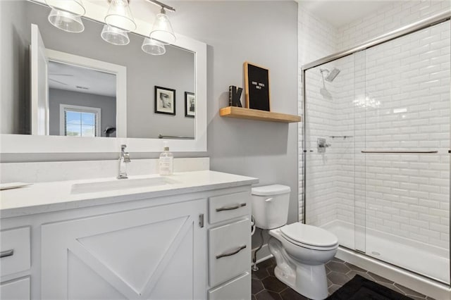 bathroom featuring vanity, toilet, tile patterned floors, and a shower with door