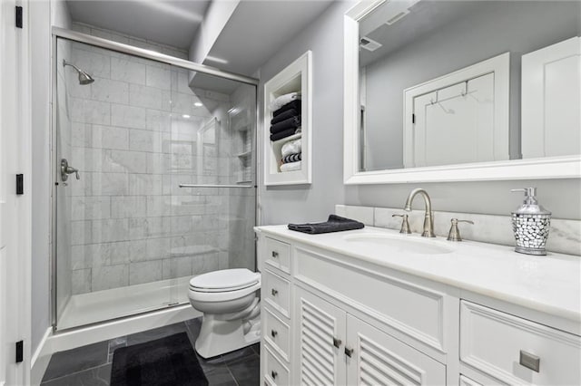 bathroom featuring tile patterned flooring, vanity, toilet, and a shower with door