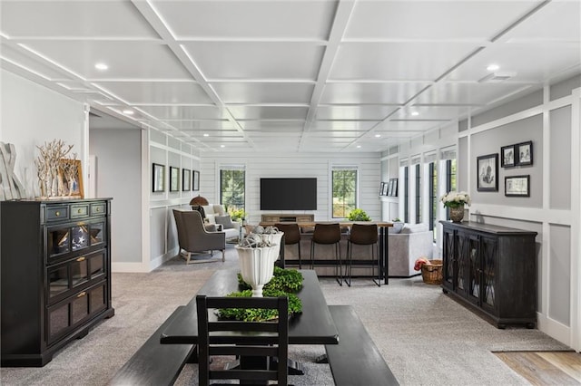 living room featuring coffered ceiling and light colored carpet