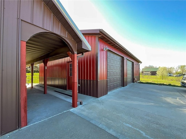 exterior space featuring a carport, a garage, and an outbuilding