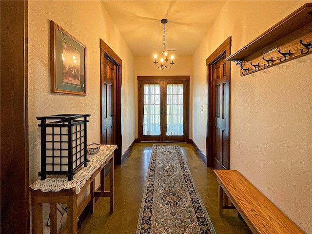 entryway featuring french doors and a notable chandelier