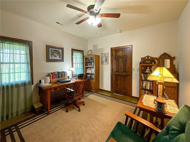 carpeted office space with ceiling fan