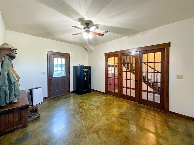 entrance foyer featuring ceiling fan, french doors, and a textured ceiling