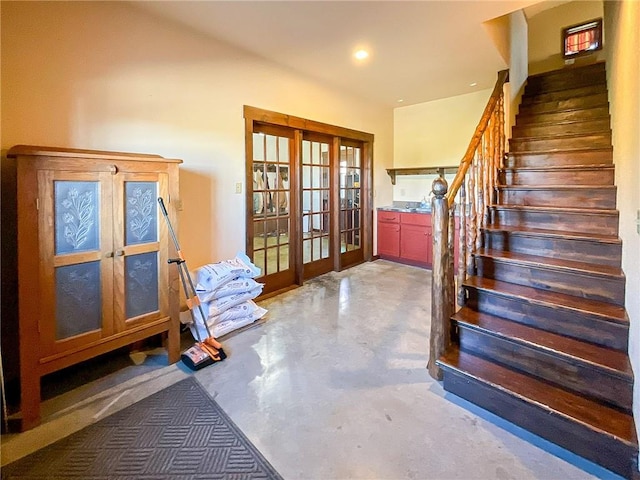 stairway featuring concrete flooring and french doors