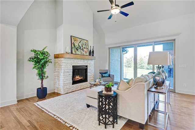 14500 Meadow Ln, Leawood, KS 66224 - living room featuring high vaulted ceiling, ceiling fan, a stone fireplace, wood finished floors, and baseboards