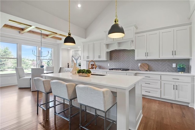 14500 Meadow Ln, Leawood, KS 66224 - kitchen featuring light countertops, backsplash, dark wood-type flooring, a breakfast bar area, and a sink