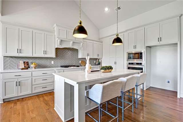 14500 Meadow Ln, Leawood, KS 66224 - kitchen featuring gas cooktop, visible vents, light countertops, backsplash, and built in microwave
