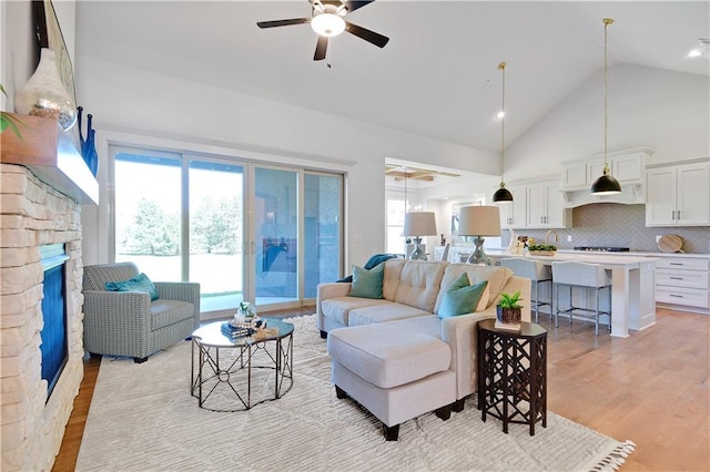 14500 Meadow Ln, Leawood, KS 66224 - living room with light wood-style flooring, high vaulted ceiling, ceiling fan, and a fireplace