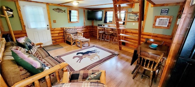 living room with light hardwood / wood-style floors and rustic walls