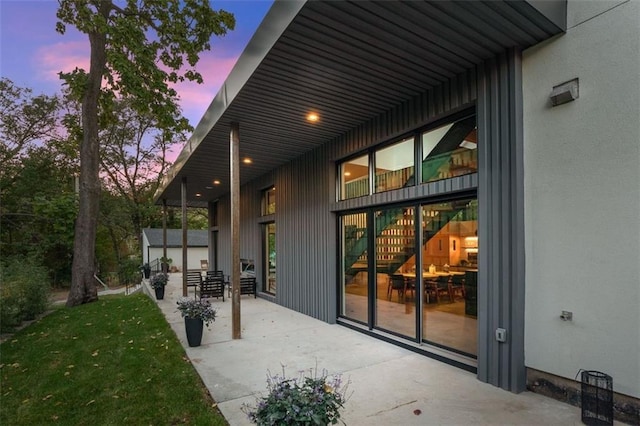 exterior entry at dusk with a patio