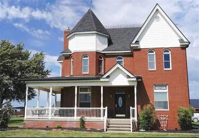 victorian house with a porch and a front lawn