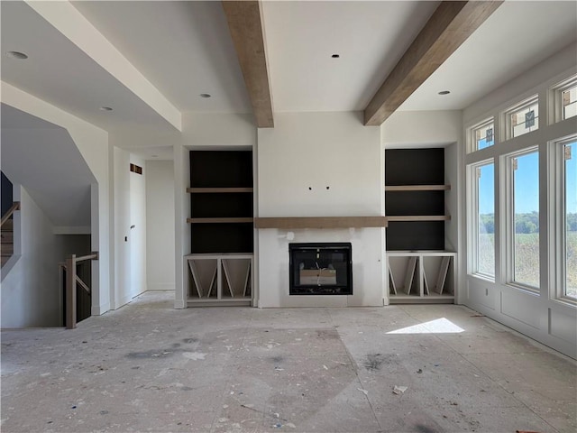 unfurnished living room featuring built in shelves and beamed ceiling