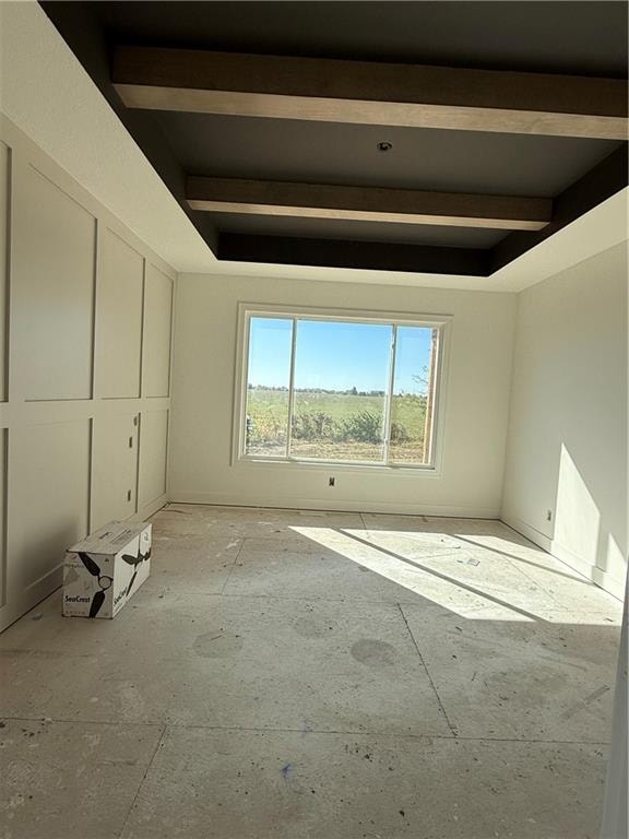 unfurnished room with beam ceiling