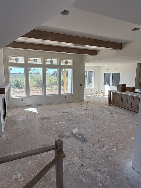 unfurnished living room with beam ceiling