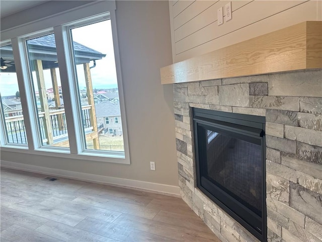 interior details with hardwood / wood-style flooring and a stone fireplace