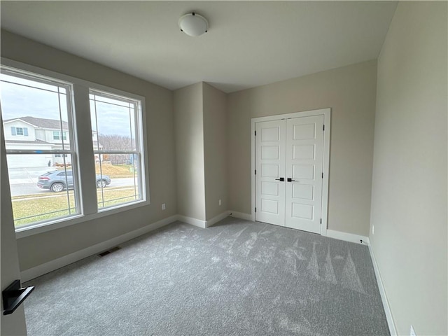 unfurnished bedroom featuring light carpet and a closet