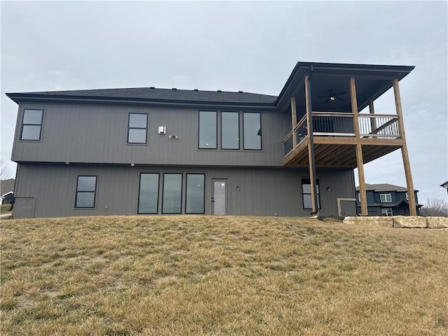 rear view of property with ceiling fan and a lawn