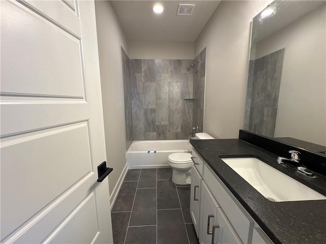 full bathroom with tile patterned flooring, tiled shower / bath, vanity, and toilet