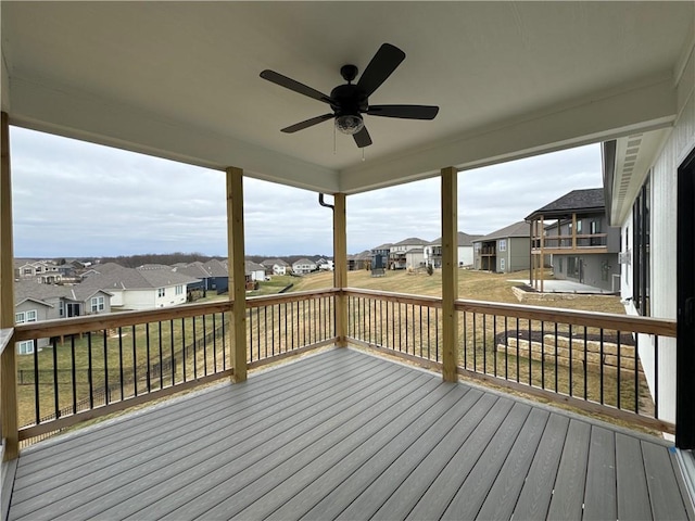 wooden terrace with a lawn and ceiling fan