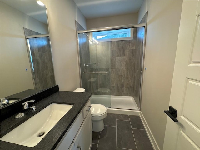 bathroom featuring tile patterned flooring, toilet, vanity, and walk in shower