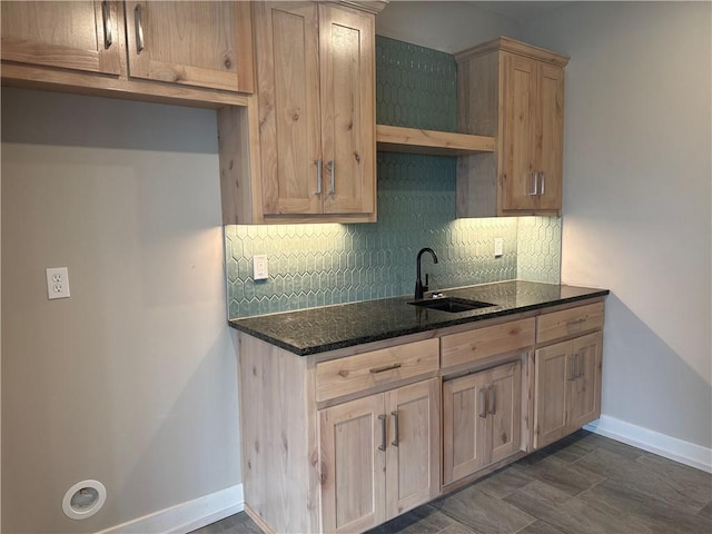 kitchen featuring dark stone counters, sink, and decorative backsplash