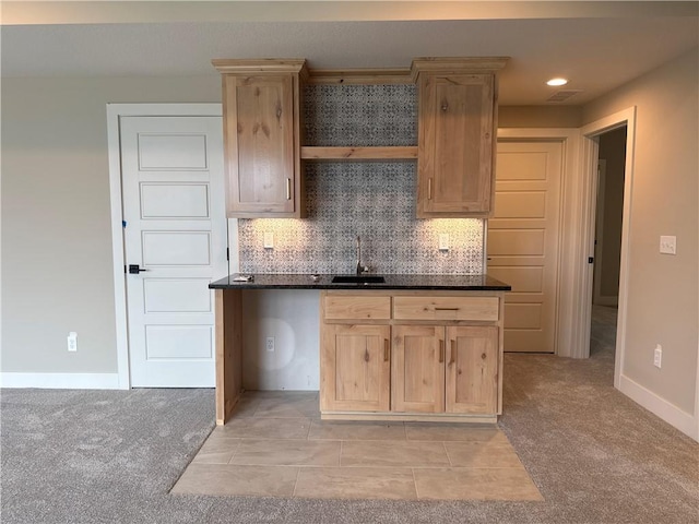 kitchen featuring light colored carpet, sink, light brown cabinets, and backsplash