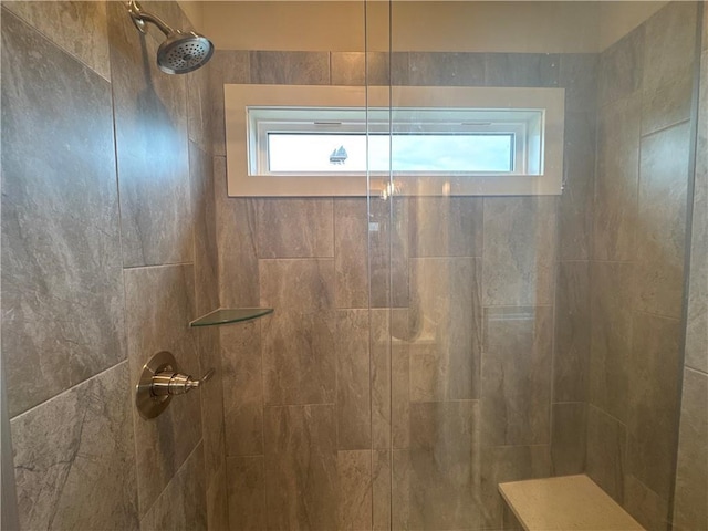 bathroom with a wealth of natural light and a tile shower