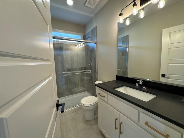 bathroom featuring vanity, a shower with door, and toilet