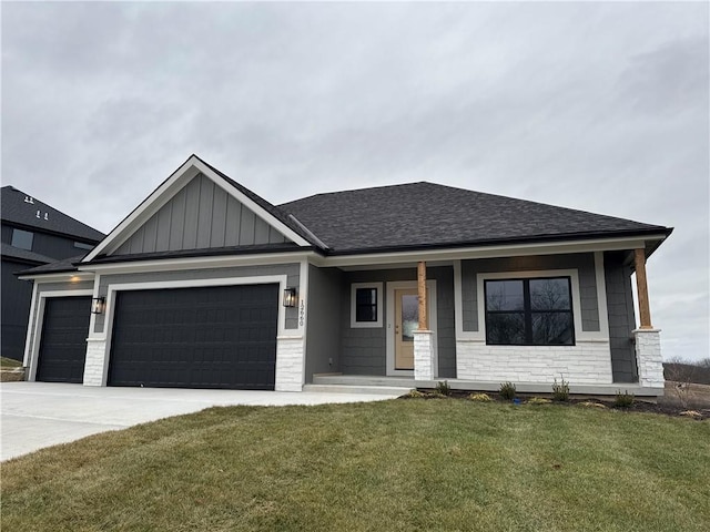 view of front of property featuring a porch, a garage, and a front yard